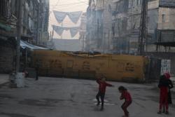 troposphera:  Children play near a bus barricading a street,