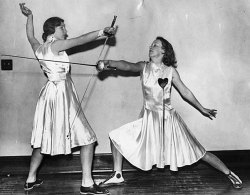 modernfencing:[ID: two women in white dresses, posing with foils.