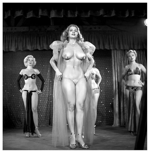 Tempest Storm    A publicity still from the 1953 Burlesque film: “A NIGHT IN HOLLYWOOD”, features Ms. Storm framed between: Misty Ayres (Left) and Jenna Saunders (Right)..  The film was shot at the ‘FOLLIES Theatre’; located in Los Angeles,