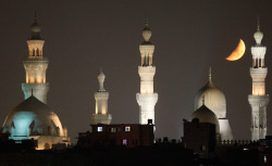   The crescent moon is seen near mosques in old Cairo on the