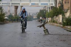 troposphera:  A resident rides his bicycle near what activists