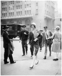 A socialite passes onlookers on Park Avenue, New York, 1928 -