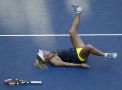 Caroline Wozniacki of Denmark stumbles as she tries to return