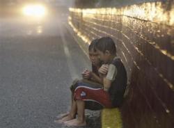 imthatninyo:  Filipino boys sit together to keep themselves warm