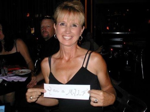 I am wondering where this took place, did someone just walk up to her and say “hello pretty lady all dressed up, please hold this sign acknowledging that you are a milf for a photo”? lol