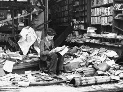 bookshelves:  A boy sits amid the ruins of a London bookshop