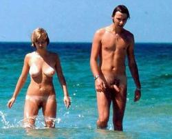 nudistlifestyle:  Nudist couple walking in the ocean. 