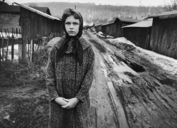 Daughter of Jobless Miner Standing in Alley Between Rows of Company