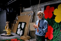  Andy Warhol in front of Flowers silk screens at The Factory,