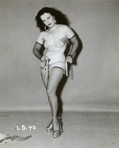 Lili Dawn removes her shimmy skirt.. From a larger photo series shot by Irving Klaw..