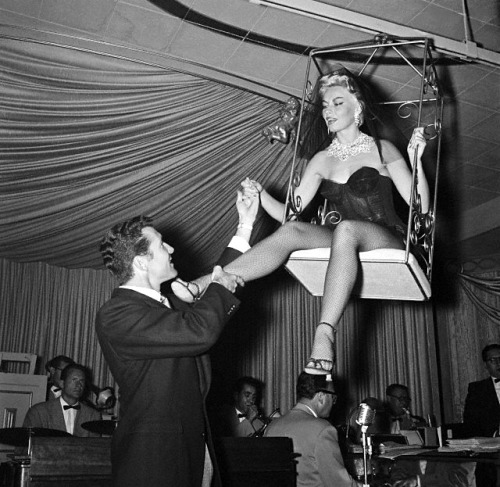 In Vegas, Ted Jordan (husband #5) lends a helping hand to lovely wife: Lili St. Cyr; who is debuting a ceiling swing routine..