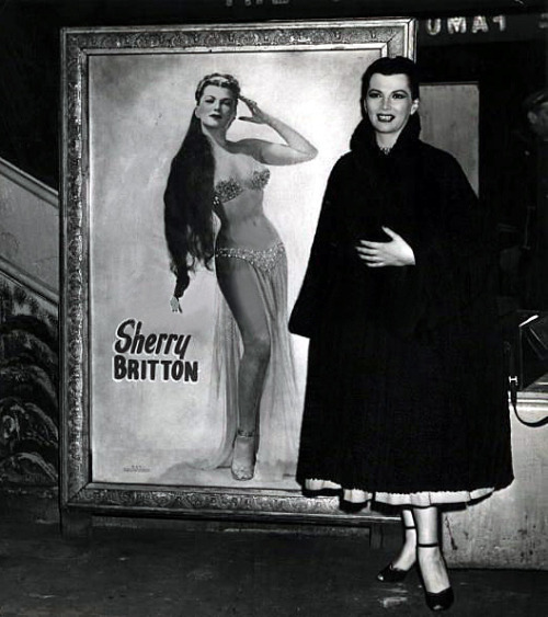 Sherry Britton    aka. “The Sweetheart Of 52nd Street”.. A press photo captures Ms. Britton posing alongside a painting based on one of her promotional photos..