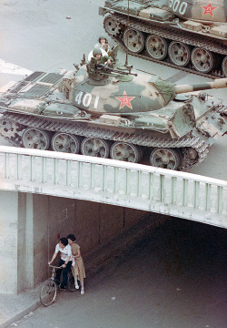 hartsell:  A Chinese couple on a bicycle take cover beneath an