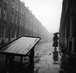 luzfosca:  A woman walks down a rainy street in post-war Whitechapel,