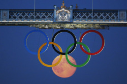  The full moon rises through the Olympic Rings, hanging beneath