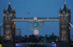 olympics:  Full moon rises through the Olympic rings at Tower