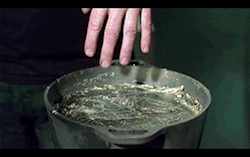 opticoverload:  A person dipping his fingers into a pot of molten
