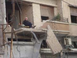 Syrian man drinking tea after his house was bombed   Not giving