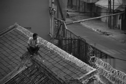 Just a guy perched on a roof wearing sunglasses…