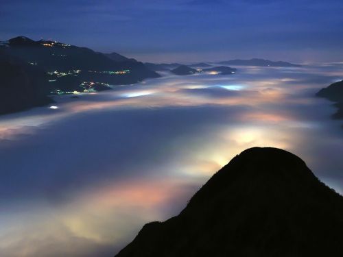 Night view as fog descends over Lago di Olginate, Italy