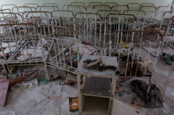  A deserted nursery school, with metals framed cots, papers and