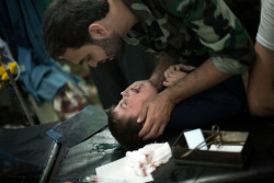 alibaadi:  Wounded by Syrian Army shelling, a child is comforted