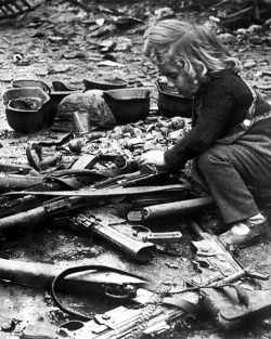 itsjohnsen:  A child plays with guns left in the streets of Berlin,