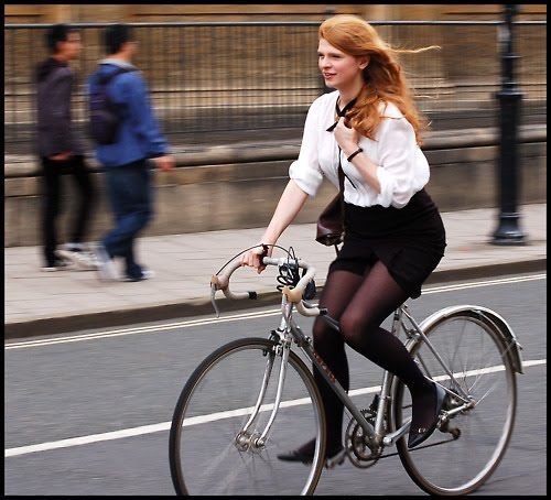 Ginger head cycling in white shirt, black skirt and tights