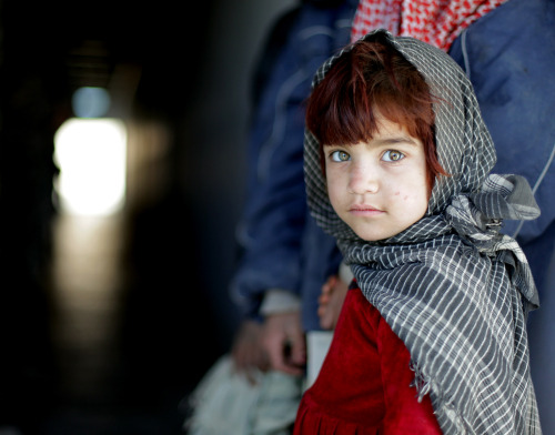 An Afghan girl walks into a clinic to receive basic medical care and clothing on Camp Clark, Khowst 