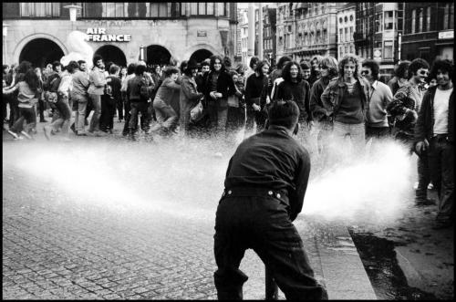  Gilles Peress NETHERLANDS. Amsterdam. 1971. Youth are amused by a man spraying water on them. 