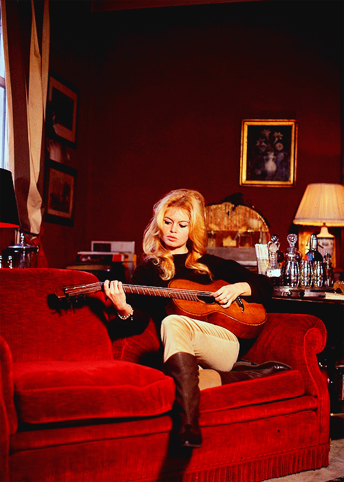 normajeanebaker:  Brigitte Bardot playing guitar in her apartment on Avenue Paul Doumer, 60’s 