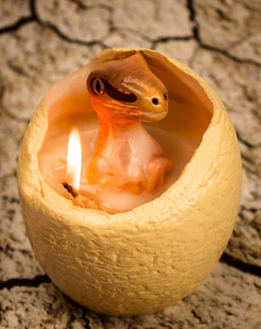 sixpenceee:  Dinosaur Egg CandleThis egg candle hatches a baby raptor when it melts. The