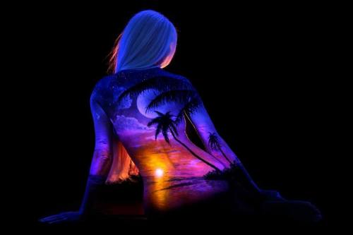 By John Poppleton. “The artist uses fluorescent pigment to paint landscapes on female models and pho