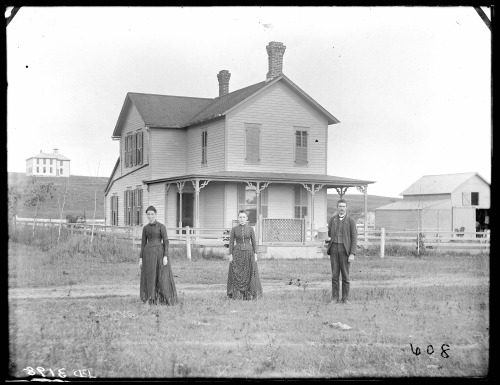 A Man, Woman, And Younger Woman In Front Of Farmhouse In East Custer County, Nebraska. 1888.