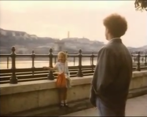 John Deacon talks to a young girl in Budapest, Hungary (1986)Girl: [says something unintelligible]De