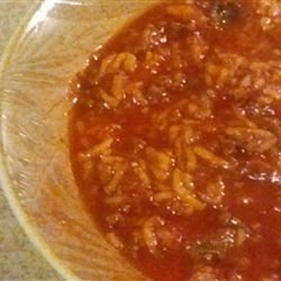 Browned ground beef is combined in this tomato based soup with chopped green peppers, cooked rice, b