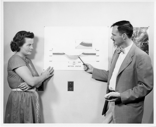 U.S. Geological Survey geologist, Eugene M. Shoemaker, and assistant pose with cross-section drawing