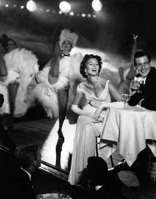 Suzy Parker and Robin Tattersall with dancers at the Moulin Rouge, Paris, August 1957. Parker wears 