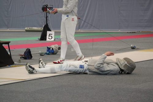[ID: three photos of a sabre fencer retreating, lying down on the strip, and then getting up again, 