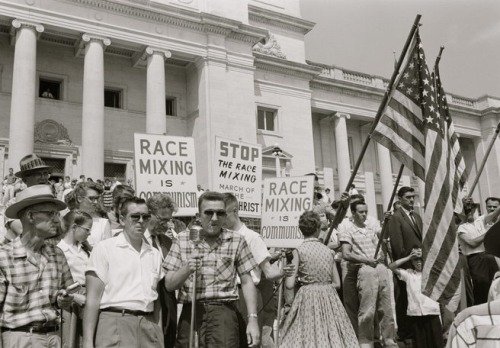 UNITED STATES - CIRCA 1959: people holding signs and American flags protesting the admission of the ‘Little Rock Nine’ to Central High School. (Photo by Buyenlarge/Getty Images)