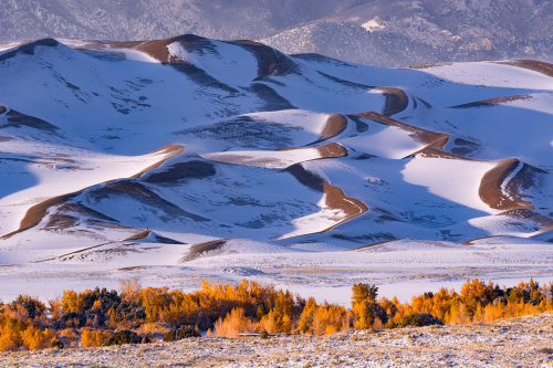 Fall transitions to winter at Great Sand Dunes National Park and Preserve in Colorado. Passing cloud