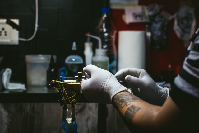 Un Artista Profesional Del Tatuaje Introduce Tinta Negra En La Piel Con Una  Aguja De Una Máquina De Tatuaje. Fotos, retratos, imágenes y fotografía de  archivo libres de derecho. Image 89451989