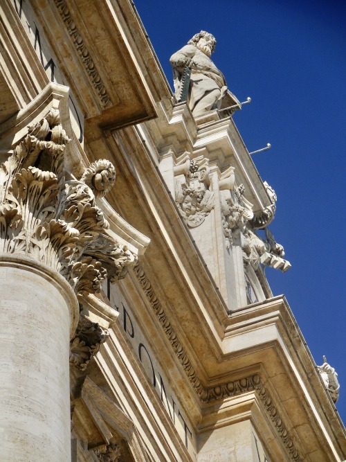 Dettagli architettonici e scultura dal basso, Piazza San Pietro, Città del Vaticano, 2019.