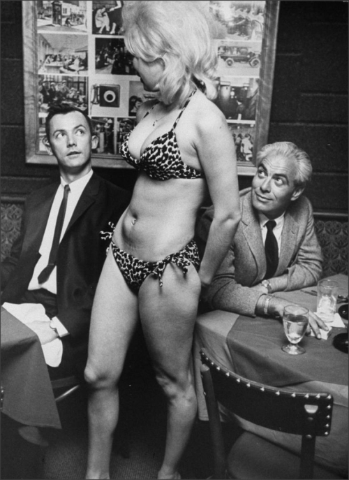 Showgirl modeling a Bikini for customers at lunchLos Angeles, 1964