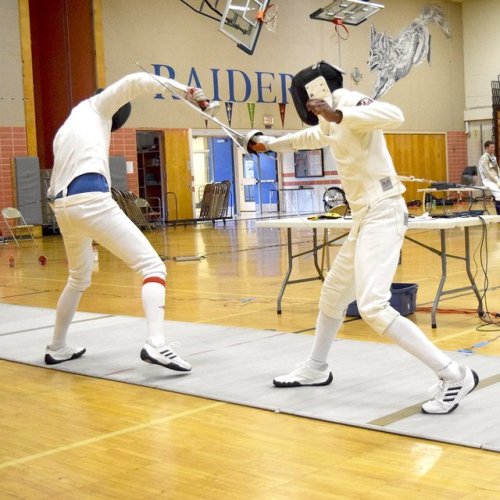 [ID: an epee fencer parrying his opponent. His jacket is coming up, revealing his shirt.]Sweet parry