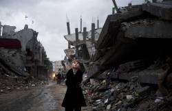  A Palestinian boy looks up during a rainstorm while walking through the destroyed Shejaiya neighborhood of Gaza City. 