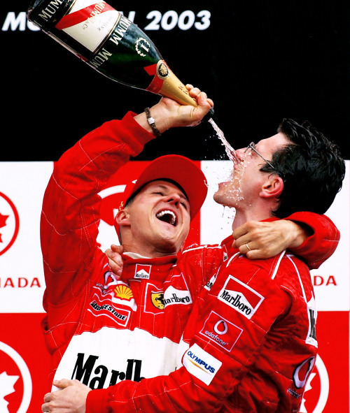  CANADA, 2003 — Michael Schumacher, 1st position, pours champagne into the mouth of his race enginee