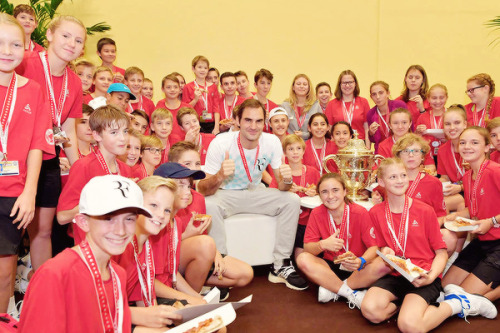 Roger Federer shares pizza with the Basel ball kids after claiming an 8th title at his hometown tour