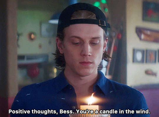 GIF FROM EPISODE 1X06 OF NANCY DREW. CLOSE-UP OF ACE AT THE CLAW. HE'S HOLDING A SINGLE LIT CANDLE IN FRONT OF HIM AT CHEST HEIGHT. WHILE LOOKING AT THE CANDLE HE SAYS "POSITIVE THOUGHTS, BESS. YOU'RE A CANDLE IN THE WIND."