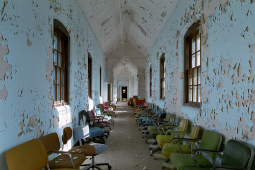 ianference:  Violent ward hallway in the main complex at St. Lawrence State Hospital, used to store a variety of colored desk chairs when the asylum was abandoned. 